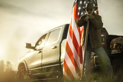 Low section of man holding american flag