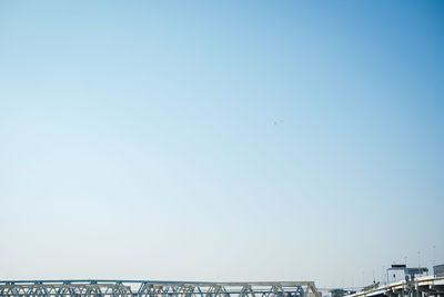 Low angle view of airplane flying against clear blue sky