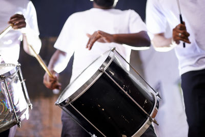 Midsection of man playing drum