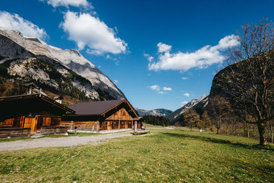 Built structure on field by mountain against sky