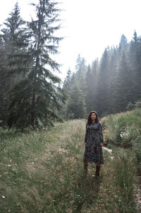 Full length of woman standing in forest