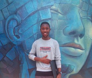 Portrait of smiling boy standing against wall