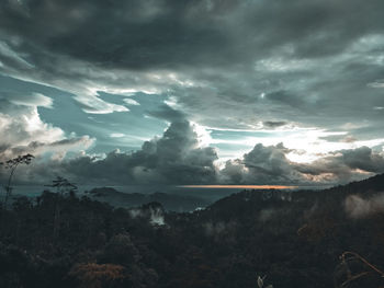 Sunlight streaming through clouds over landscape