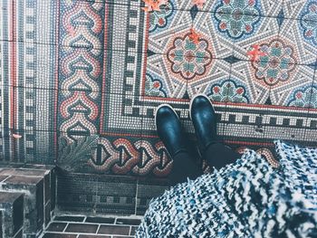 Low section of man standing on tiled floor