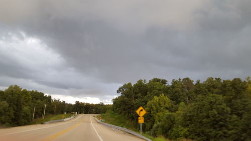 Road amidst trees against sky