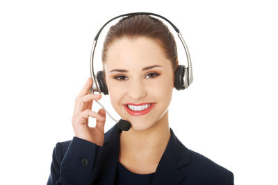 Portrait of smiling businesswoman wearing headset against white background