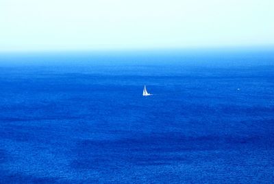 Sailboat in sea against clear sky