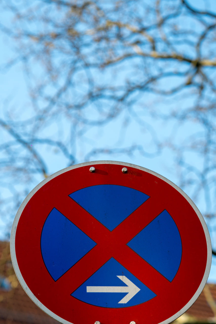 CLOSE-UP OF ROAD SIGN AGAINST TREES