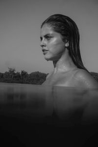 Portrait of woman looking away against sky