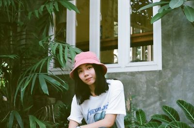 Portrait of confident young woman sitting outside house