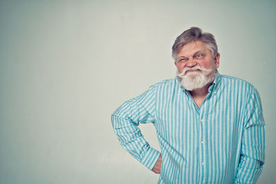 Portrait of man standing against gray background