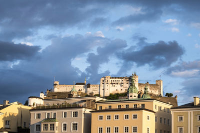 Low angle view of buildings against cloudy sky