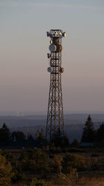 Low angle view of communications tower against sky during sunset