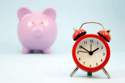Close-up of clock against pink background