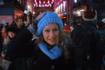 Portrait of smiling woman wearing warm clothing and knit hat at night