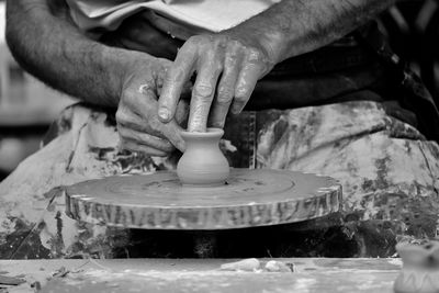 Cropped image of man working with clay on a pottery wheel. 