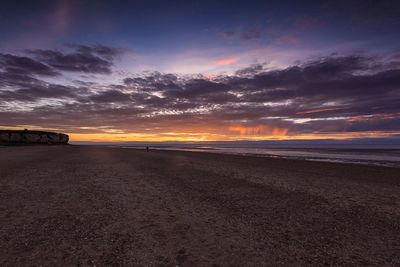 Scenic view of sea against dramatic sky during sunset