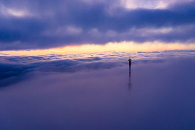 Communications tower rising above a sea of clouds at sunrise, salzburg, austria