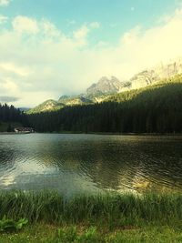 Scenic view of lake by mountains against sky