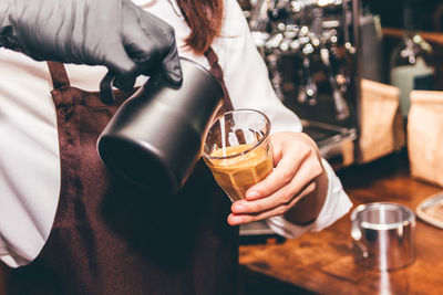 Midsection of woman drinking glass