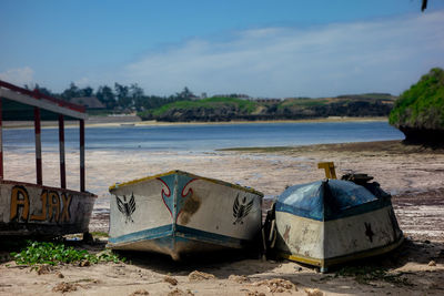 Boats moored on beach against sky