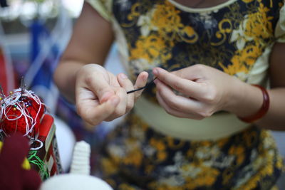 Cropped image of woman making crafts at table