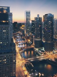 High angle view of illuminated buildings in city at dusk