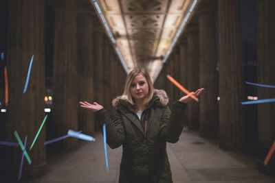 Woman throwing colorful toy while standing under bridge