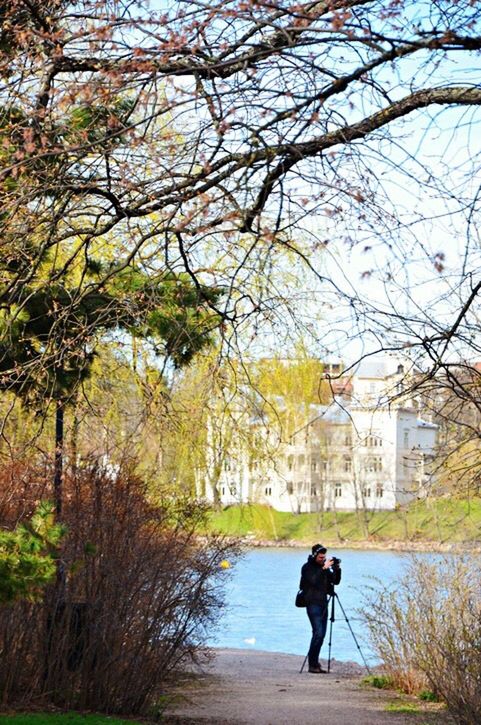 REAR VIEW OF WOMAN WALKING ALONG TREES