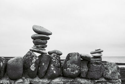 Stack of stones on beach against clear sky