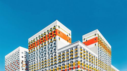 Low angle view of office building against clear blue sky