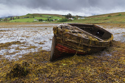 Old ruin on field against cloudy sky