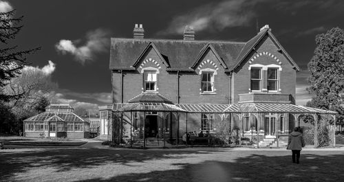 House by buildings against sky