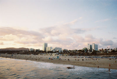 City at waterfront against cloudy sky