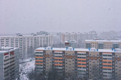 Buildings in city against sky during rainy season