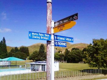 Low angle view of road sign against blue sky