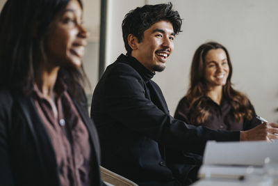 Smiling businessman with female colleagues during meeting in board room at office