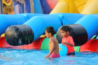 Boys playing in swimming pool at resort