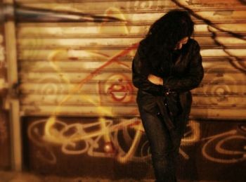 Woman standing by wall