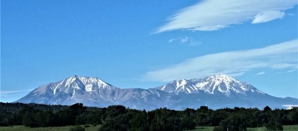 Scenic view of mountains against blue sky