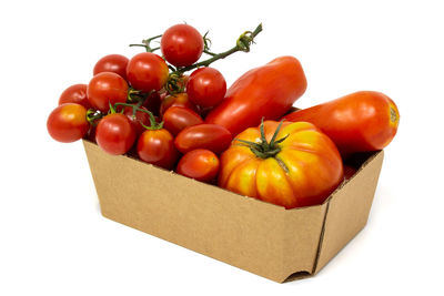 High angle view of tomatoes in box against white background