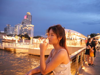 Portrait of smiling young woman looking away in city