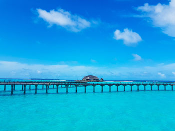 Pier over sea against blue sky