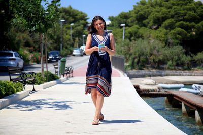 Full length of woman walking on footpath in city