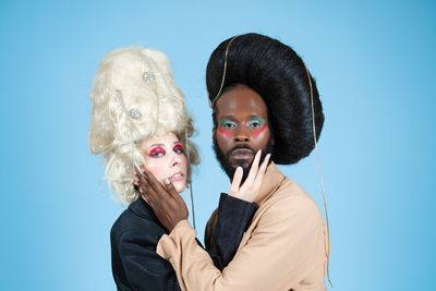 Portrait of young woman wearing mask against blue background