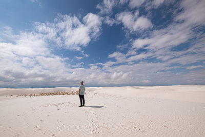 Rear view of man on sand at desert