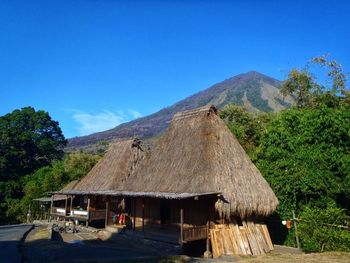 Scenic view of village and mountains against clear blue sky