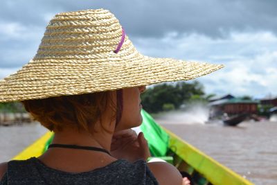 Rear view of woman wearing hat against sea