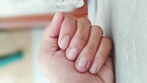 Close-up of hand touching wall