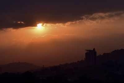 Silhouette buildings against sky during sunset